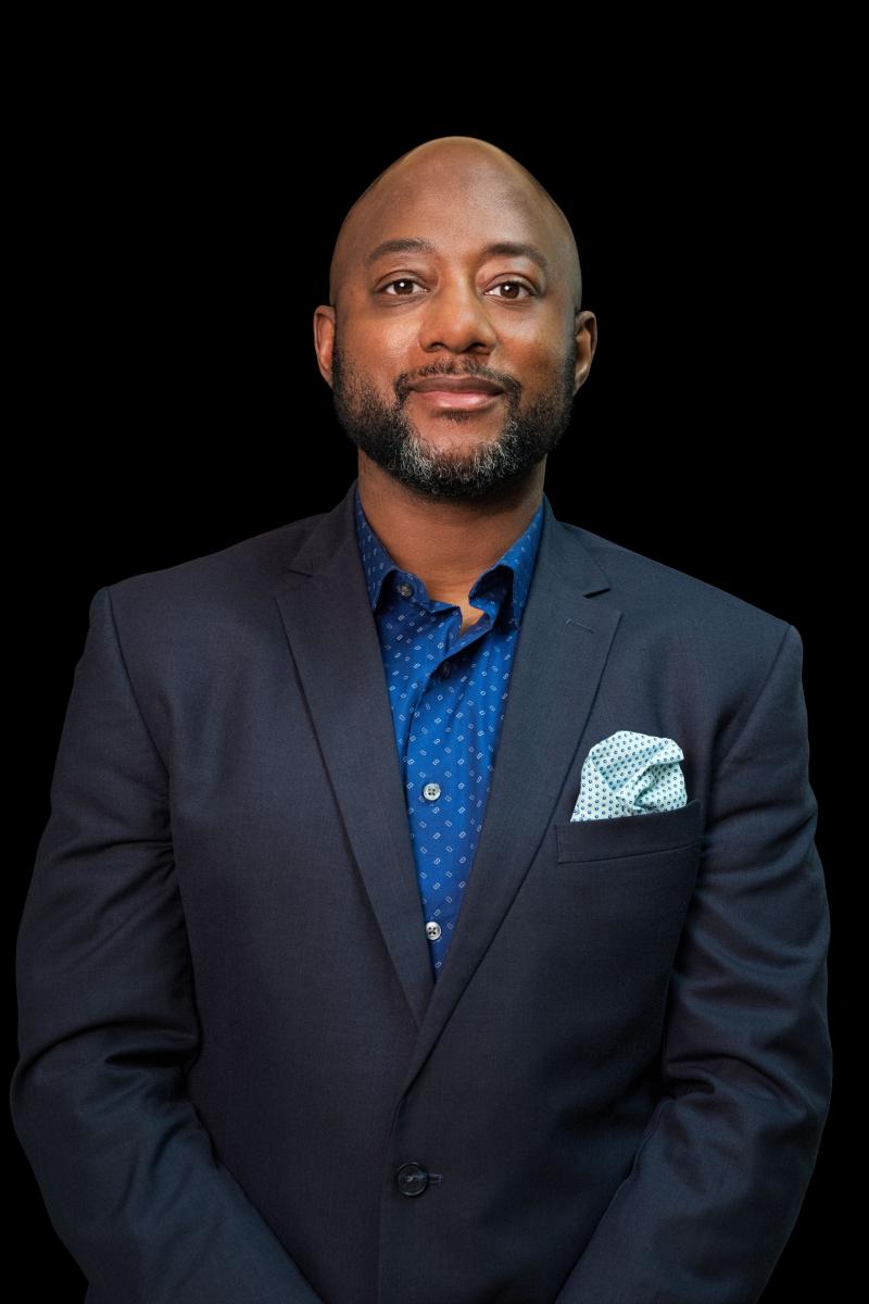 Image of man wearing blue polka dot button up with navy blazer