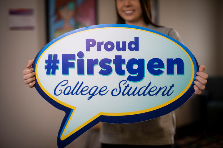 girl holding poster saying Proud first gen college student
