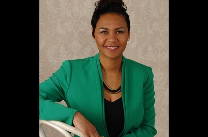 woman in green blazer smiling for camera