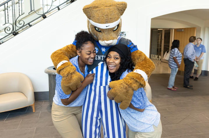 two students hugging Wildcat mascot 