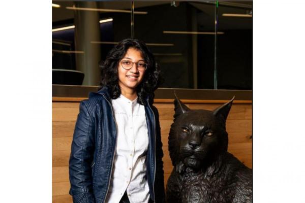 image of student next to wildcat statue