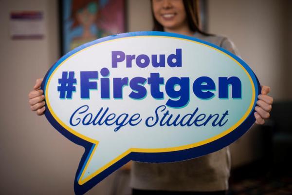 girl holding poster saying Proud first gen college student