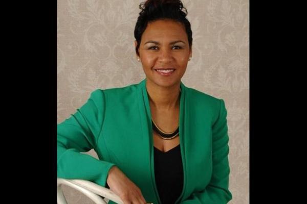 woman in green blazer smiling for camera