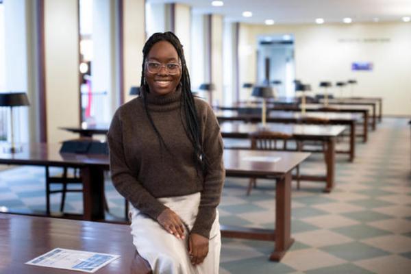 Black female student smiling for camera in library