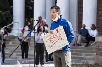 Image of Asian man speaking at rally in support of Asian community