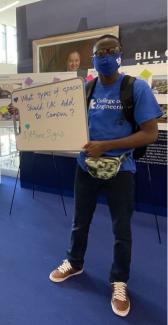 male student holding white board 