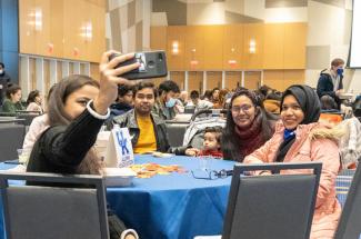 family at round table smiling for selfie