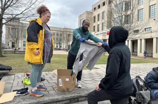 Jonathan Richardson and a volunteer offer clothing to community members in need in Lexington. 